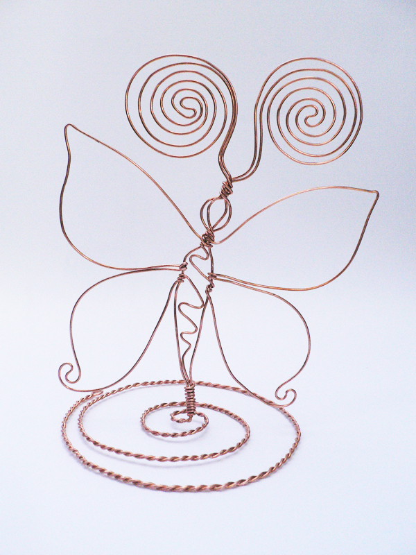 una bellissima farfalla in filo di rame su base a spirale intrecciata. Le antenne a spirale possono servire da portafoto